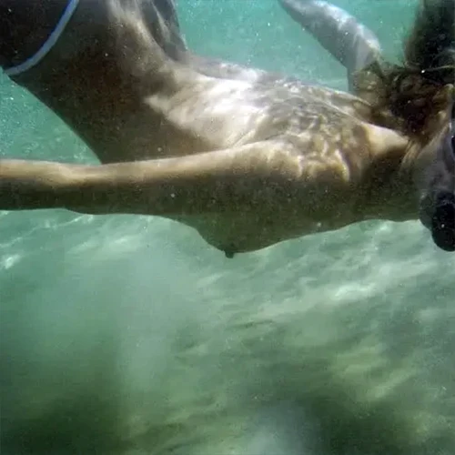 Nude woman swimming in ocean